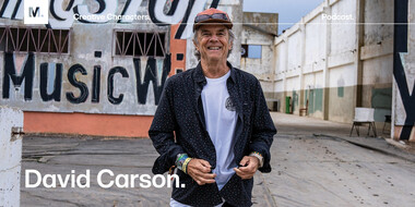 Graphic designer and design director David Carson standing in front of a wall that says Music